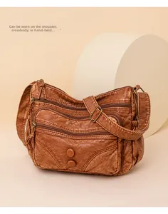 Detailed view of brown washed PU leather crossbody bag with multiple zip pockets