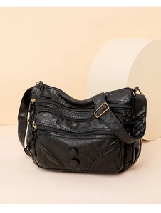 Close-up of black PU leather bag showing three parallel zipper pockets and textured surface