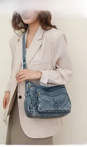 Model wearing a vintage dark gray washed PU leather crossbody bag with multiple zippers