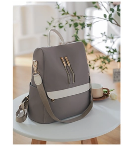 Dettaglio zaino oxford grigio impermeabile con finiture in pelle beige e cerniere dorate