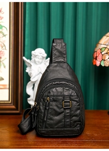 Detailed view of black washed faux leather chest bag with vintage bronze zipper pockets