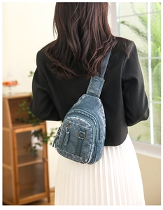 Detail showing vintage teal washed leather texture and dual zipper design on chest bag