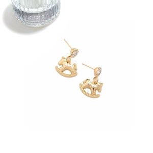 Detailed close-up of golden rocking horse earrings with sparkling zircon and hammered texture