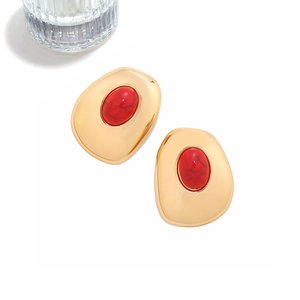 Detail view of gold vintage earrings with irregular geometric faux turquoise stone inlay