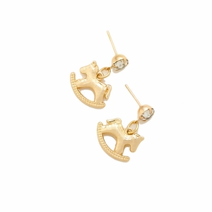 Close-up of golden rocking horse earrings with sparkling rhinestone studs on white background
