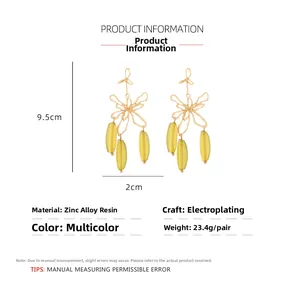 Detail view of 9.5cm hollow metal flower earrings with yellow resin drops and measurements