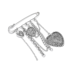 Macro detail of vintage silver multi-chain brooch with hollow heart and oval pendants