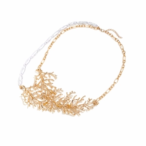 Close-up of golden coral pendant and white baroque pearls on a designer necklace