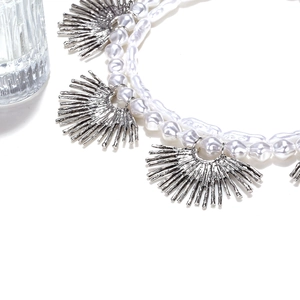 Detail of layered baroque pearl necklace with silver sun pendants and bohemian tassels