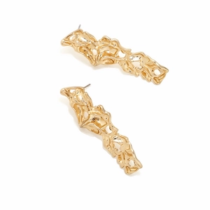 Detail view of gold hollow lava textured earrings with a modern fluid geometric design