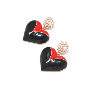Détail de boucles d'oreilles cœur en émail avec fermeture éclair dorée et perles
