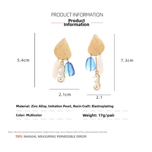 Detail view of asymmetric shell and seahorse earrings with pearls and dimensions