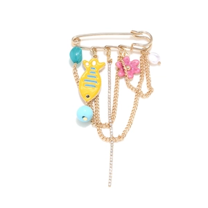 Gold pin brooch with tropical fish, pink flower and turquoise beads on white background