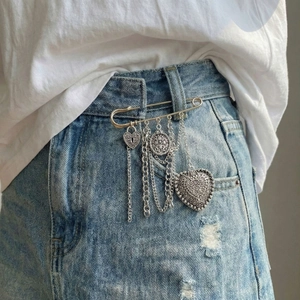 Retro silver heart chain tassel pin with lock and coin charms on denim skirt