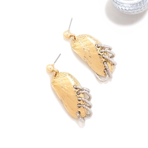 Detailed close-up of shell-shaped gold earrings with textured silver ring accents