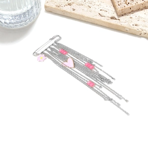 Detail of silver long tassel brooch with pink heart and flower charms on white background