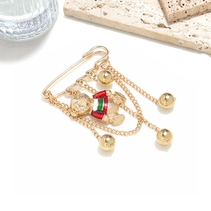 Détail d'une broche épingle dorée avec pendentif ours émaillé et chaînes à pampilles