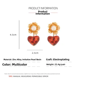 Detailed view of resin heart earrings with floral pearls and 4.5cm size markings