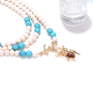 Collana multistrato bohémien con perline turchesi e pendente a corallo con scarabeo