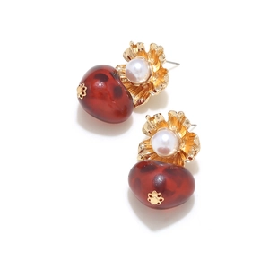 Macro shot of resin leopard print heart drop with gold petal and white pearl earring