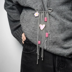 Pink heart and daisy tassel brooch pin accessory on a grey knitted sweater