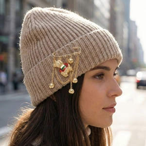 Bonnet en tricot avec broche ours dorée et détails de pompons rayés colorés