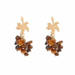 Detailed view of gold leaf stud earrings with natural tiger eye stone bead tassels
