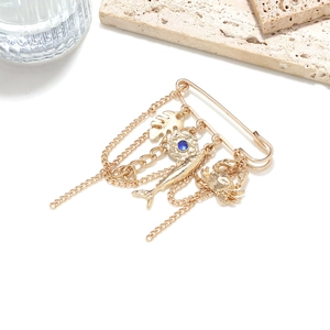 Golden multi-pendant brooch featuring ocean animals and blue gems on a white background