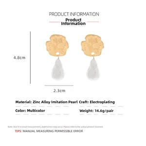 Detailed view of baroque pearl earrings with textured gold coin and size dimensions