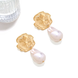 Close-up of hammered gold coin earrings with natural baroque pearl drops on white background