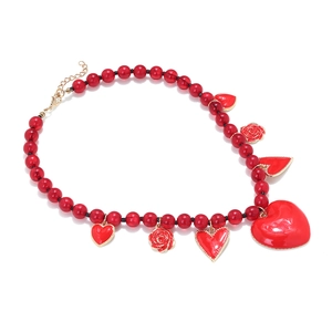 Detail of red beaded necklace featuring enamel heart pendants and golden rose charms
