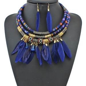 Detail of bohemian handmade multi-layer woven necklace and blue feather earrings set