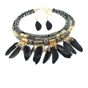 Detail of bohemian necklace with black feathers, woven fabric and metal coils