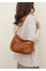 Close-up of vintage brown washed PU leather shoulder bag with multi-pocket details