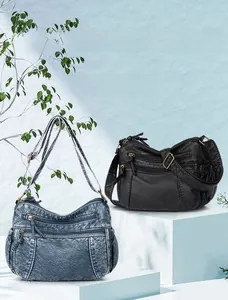 Detailansicht der Damenhandtaschen in Denim-Blau und Schwarz mit mehreren Reißverschlüssen
