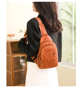 Detail der braunen Vintage-Brusttasche aus gewaschenem Leder mit Reißverschlussfächern
