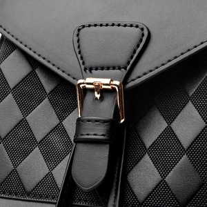 Black leather quilted backpack with gold metal buckle and pebble grain texture
