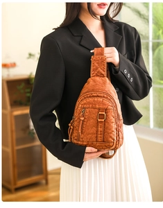 Detail of vintage brown textured PU leather chest bag with multiple zipper pockets