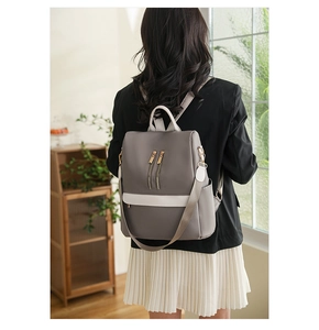 Dettaglio dello zaino antifurto da donna grigio e beige con cerniere color oro eleganti