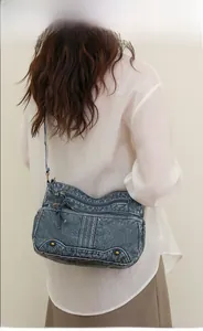 Détail du sac bandoulière en cuir bleu vintage avec fermetures éclair et rivets pratiques