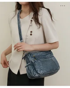 Detail einer graublauen Vintage-Schultertasche mit doppelten Reißverschlusstaschen