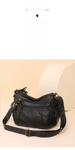 Detailansicht der schwarzen Retro-Ledertasche mit mehreren Reißverschlussfächern und Messingteilen