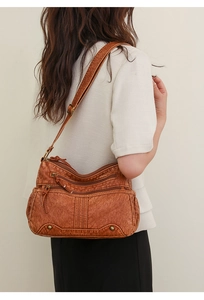 Bandoulière réglable et détails en bronze vintage sur le sac à bandoulière marron rétro