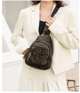 Detail view of vintage dark brown PU leather chest bag with multi-layer zippers