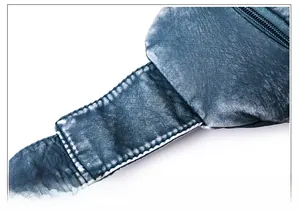 Nahaufnahme der weißen Kontrastnähte auf einer blauen Brusttasche aus Waschleder