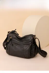 Detailansicht der schwarzen Mehrfachtaschen-Umhängetasche aus weichem Leder mit Gold-Zips