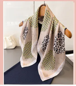 Detail of elegant leopard print silk scarf showing smooth texture and geometric patterns