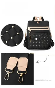Close-up of golden metal hooks and durable nylon material on black backpack