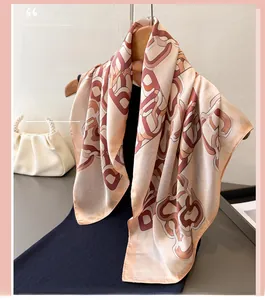Detail view of premium silk scarf with red floral prints hanging on a wooden hanger