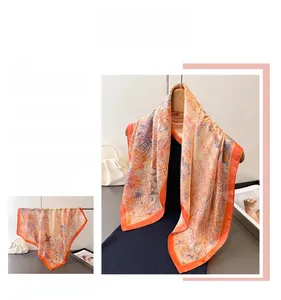 Detailansicht eines eleganten Seidenschals in Orange und Lila mit sanftem Seidenglanz